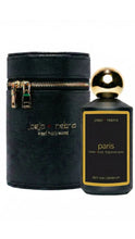 Load image into Gallery viewer, A dark bottle of Jojo Nebra Paris home and body fragrance spray next to its black cylindrical carrying case with gold hardware, on a white background.