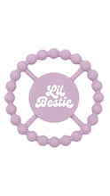 Load image into Gallery viewer, A lavender silicone baby teether with a circular beaded outer ring and a central round pad featuring the white script text 'Lil Bestie'.