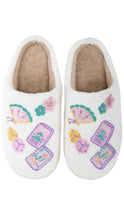 Load image into Gallery viewer, A pair of white fuzzy slip-on slippers with embroidered colorful motifs including flowers, butterflies, and cards, shown against a plain white background.