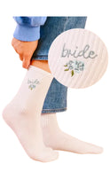 Load image into Gallery viewer, White socks with 'bride' embroidery worn by a person, with a close-up of the embroidery on a white background.