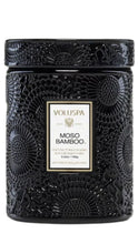 Load image into Gallery viewer, A black textured jar candle with an embossed circular pattern and a central white label reading VOLUSPA MOSO BAMBOO.