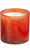 Load image into Gallery viewer, A scented candle in a cylindrical glass jar with a vibrant orange and red marbled pattern and subtle gold glitter flecks, set against a plain white background.