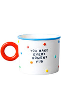 Load image into Gallery viewer, White ceramic mug with colorful raised dots, a bright red circular handle, blue rim, and black text reading “You Make Every Moment Fun.”