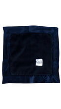 Load image into Gallery viewer, A navy blue baby blanket featuring a plush velvet center panel and a satin-like border, with a small white brand label on the front.