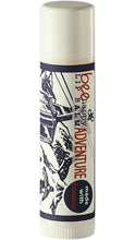 Load image into Gallery viewer, Bee Happy Lip Balm in a cream-colored lip balm tube featuring an illustrated snowy ski scene and the phrase “Adventure,” with a “made with beeswax” label.