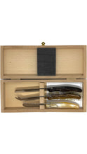 Load image into Gallery viewer, A wooden presentation box with a hinged lid, shown open against a white background. Inside, a dark gray felt-like pad is placed on the upper compartment, and the lower compartment holds several knives or cutlery pieces arranged in a holder.
