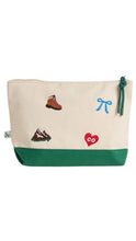 Load image into Gallery viewer, A canvas zippered pouch with a cream-colored upper and a green bottom band. The cream section features embroidered motifs including a brown hiking boot, a blue bow, a red heart with 'co' inside, and green mountains.
