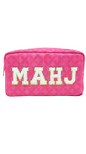 Load image into Gallery viewer, A pink zippered cosmetic pouch featuring a repeating geometric pattern and the letters 'MAHJ' in large cream-colored block letters outlined with gold trim across the front.
