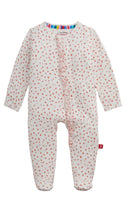 Load image into Gallery viewer, A baby footed one-piece sleeper in a warm off-white fabric with a small red floral print, featuring a ruffle detail down the front and a colorful striped inner collar.
