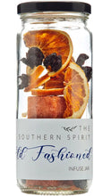 Load image into Gallery viewer, The Southern Spirit Old Fashioned Infuse Jar filled with dried orange slices, dark cherries, spices, and sugar cubes in a clear glass jar with a black lid.
