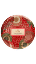 Load image into Gallery viewer, A round tin Voluspia Tomato Trellis candle, featuring a vibrant red background with a raised floral trellis pattern in red, beige, and olive green, and a central cream label.
