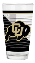 Load image into Gallery viewer, Clear University of Colorado Buffaloes pint glass featuring the CU buffalo logo in black and gold over a geometric black, white, and gold striped design, shown against a white background.
