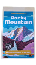 Load image into Gallery viewer, Bag of Park Pass Coffee Rocky Mountain Colombia &amp; Mexico blend featuring a colorful illustrated mountain landscape in blue, purple, burgundy, and white. The package notes flavors of dark chocolate, caramel, brown sugar, and fuel, with the Park Pass Coffee logo and “Coffee That Gives Back to Our Parks” displayed on the front.
