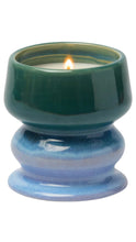 Load image into Gallery viewer, A ceramic candle holder with a lit candle, featuring a glossy dark green top section and a glazed blue bottom pedestal base, isolated on a white background.
