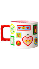 Load image into Gallery viewer, A white ceramic mug with a bright red handle and a pink interior, decorated with colorful whimsical illustrations including a butterfly in a heart, small framed art pieces, and flowers.

