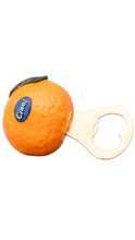 Load image into Gallery viewer, An orange-shaped bottle opener with a heart-shaped blade, featuring a textured orange body, a small green leaf, and a blue oval sticker with the brand name 'Ciao!' in white text.
