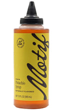 Load image into Gallery viewer, Clear squeeze bottle of Motif Premium Pistachio Syrup with amber-colored syrup, a chartreuse label with black lettering, and a black dispensing cap. The 12 fl oz bottle is labeled naturally flavored.
