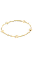 Gold bracelet with cross-shaped charms on a white background