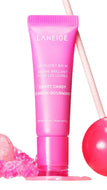 LANEIGE Sweet Candy Lip Glowy Balm in a bright pink squeeze tube, styled with pink candy on a white background.